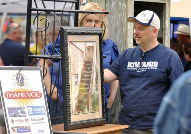 Eric Scott describes auction items to potential bidders at the annual Kiwanis Club Auction fundraiser at Haller Park on Thursday