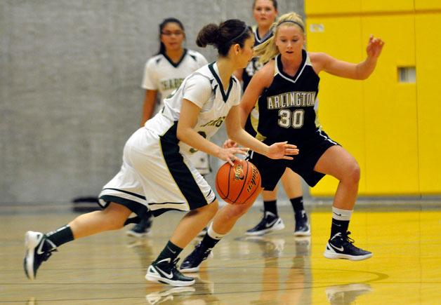 Arlington junior guard Winter Brown works to cut off a Marysville Getchell drive on Dec. 27.