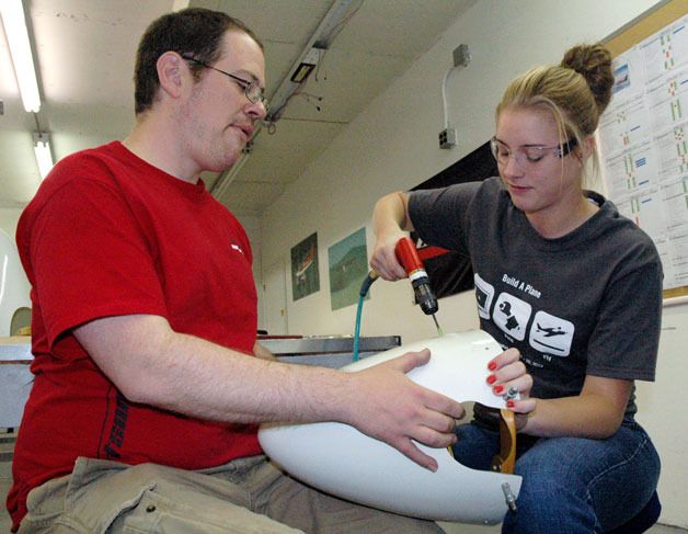 Glasair Aviation technician Ben Watson holds the aircraft parts steady while Julia Garner of Saline High School in Michigan does the work on June 21.