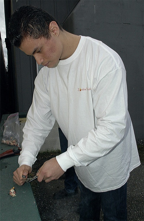 Isaiah Raether of Arlington strikes metal with a rock to create a spark to start a fire using 'Zombie Tinder