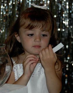 Three-year-old Mikayla Anderson of Arlington looks at a question she pulled out of a jar during the question-and-answer portion of the Crowns for Hope Pageant.