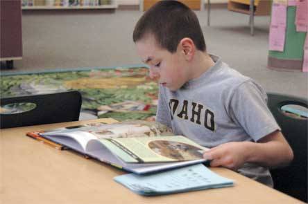 Pioneer second-grader Tommy Hayman reads a book in the library Feb. 4. Students at the school are currently competing in an Olympic Games-themed reading contest.