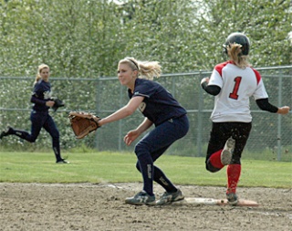Arlington first baseman Allie Milless is still waiting for a pass as the Snohomish runner crosses the base.