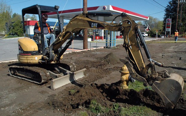 Heavy equipment operator Matt Loukes excavates to perform underground line work on 67th Avenue NE near the 76 gas station on April 22.