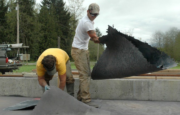 Randy Opel and Chris Evans work on concrete flooring at the Fruitful Farm & Nursery in Oso.
