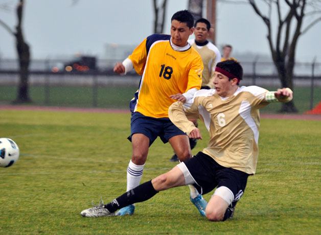 Lakewood senior Brandon Ochoa slides to take the ball away from Burlington's Alex Rincon.