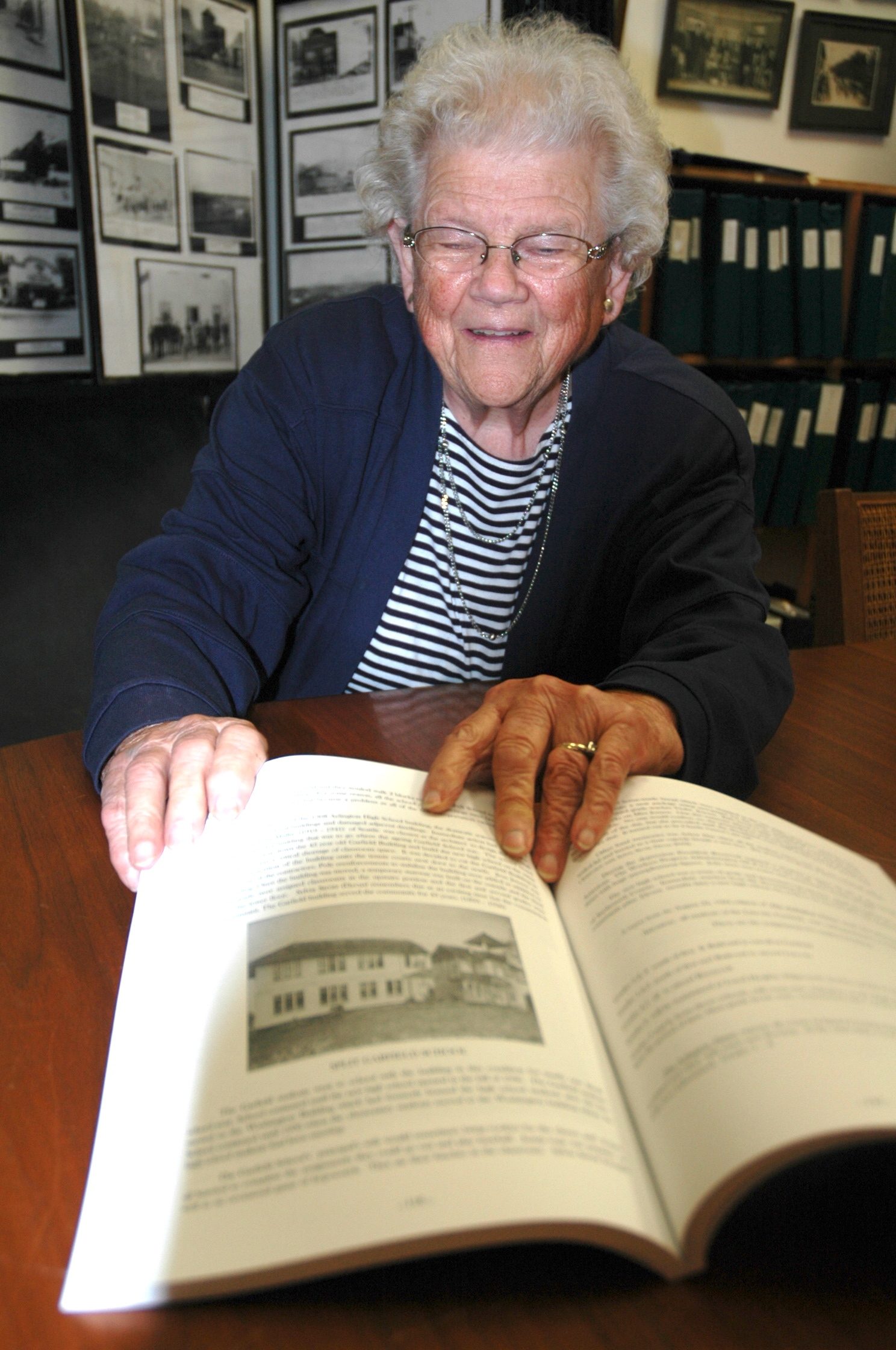 Kirk Boxleitner/Staff PhotoShirley Prouty points out some of the historical photos she acquired while compiling the first volume of “100 Years of Arlington WA.”