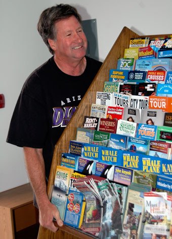 Dave Kuhl puts his back into moving a shelf of Visitor Information Center pamphlets into the Arlington-Smokey Point Chamber of Commerce’s new offices on July 28.