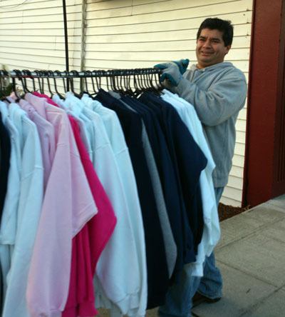 Fo Gonzales carries a rack clothes down Olympic Avenue from Action Sports’ old address to its to new location.