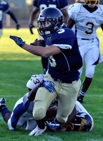 Arlington senior halfback Colton Hordyk fights through wouldbe tackler Dominique Law on his way for a first down.