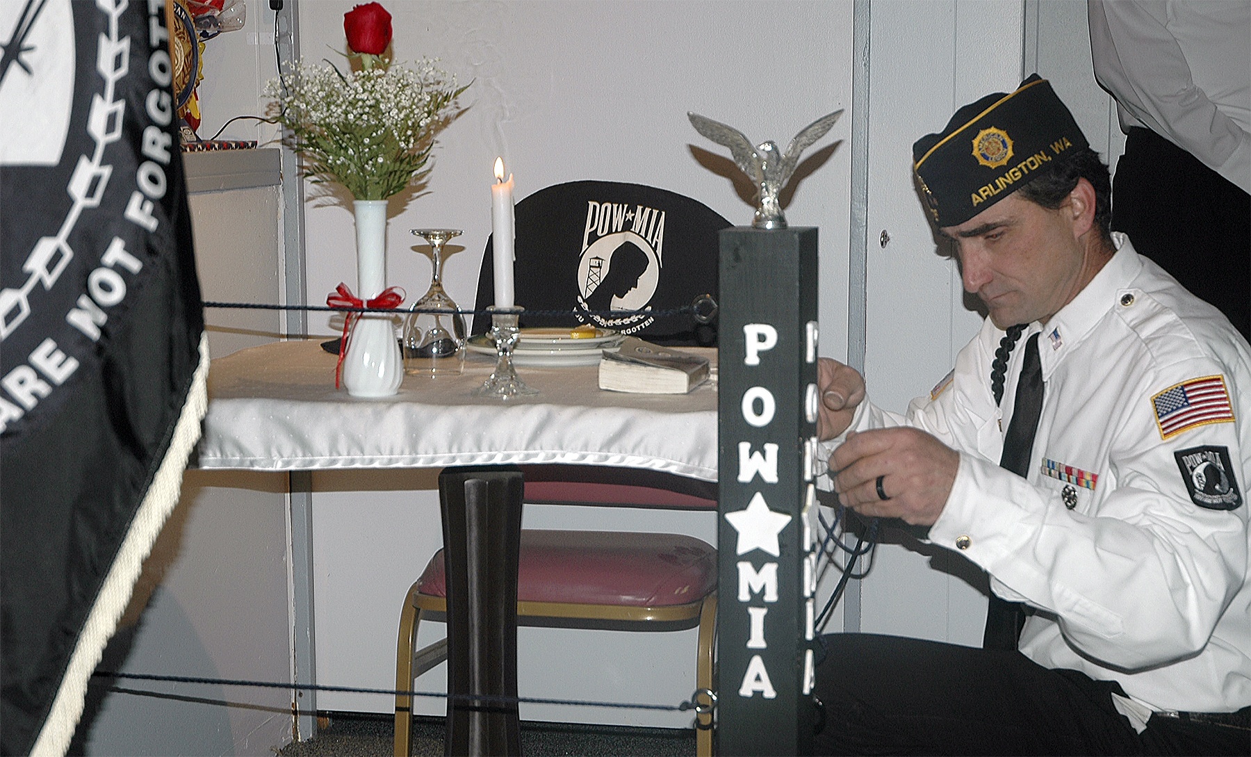 Kirk Boxleitner/Staff PhotoArlington American Legion Post 76 member David Delancy re-secures the cordon around the POW/MIA table in the Legion Lounge Sept. 16.