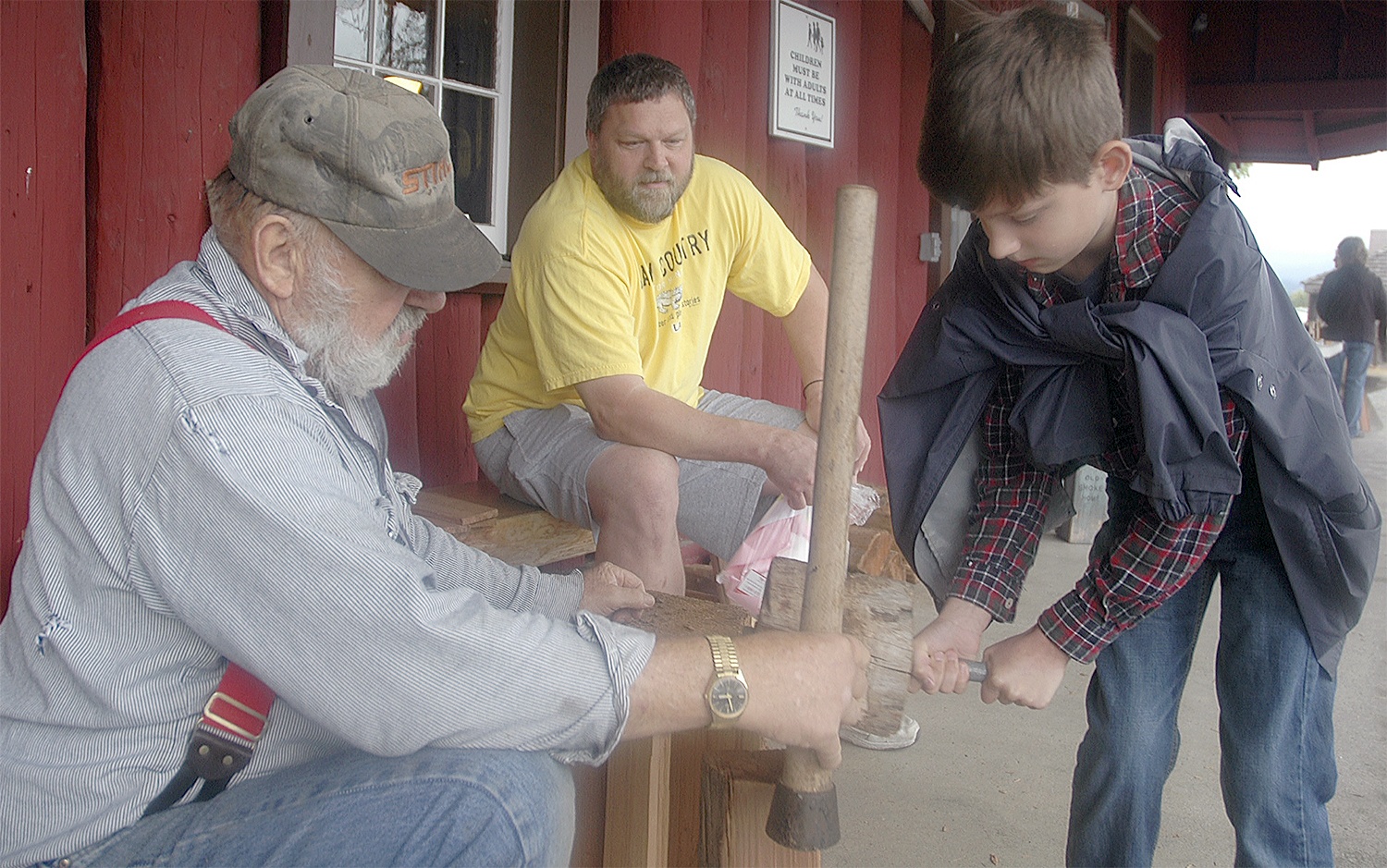 Kirk Boxleitner/Staff PhotoRay Miller guides Nathan Perry through splitting his own shake shingles from old-growth cedar.