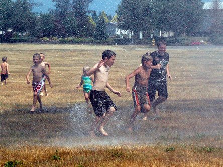 Arlington youth splash in the cool mist of a giant shower provided by the Arlington Fire Department. Local residents who missed out July 25-26 can get another chance July 29 at Kent Prairie Elementary School in Arlington.