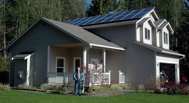 Tom Flandro stands outside of his solar-powered home in Arlington.