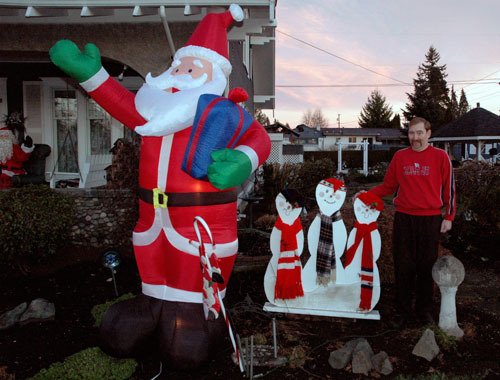 Jerry Vanney proudly shows off the inflatable Christmas decorations that he puts up in the front yard of his house every year.