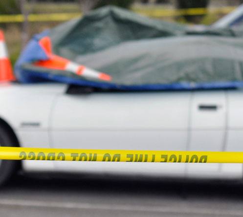 Police tape surrounds a white two-door vehicle in the Arlington Haggen parking lot after human remains were found inside on Thursday