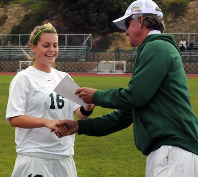 Point Loma Nazarene sophomore defender and Arlington High School graduate Jessica Van Loo receives a Brine Method Champions of Character scholarship certificate from PLNU assistant athletic director Art Wilmore on Nov. 19.