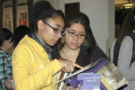 Arlington High School seniors Tameka Siplin and Melania Baublitz look over college application materials from a vendor Jan. 15 during the Students of Color Conference at Everett Community College.