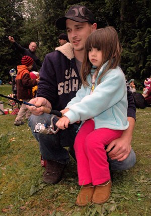 Arlingtonâ€™s Joey Baker helps his 3-year-old daughter Addison out with her rod and reel at the May 18 kidsâ€™ fishing event at Twin Lakes County Park.