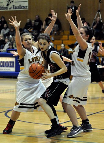 Highland Christian forward Jade Olin gets trapped by a pair of Lopez Island defenders.