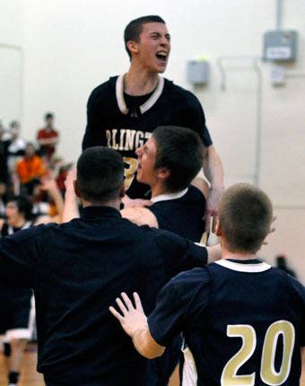 Arlington senior Zach Cooper celebrates by jumping on top of a teammate after defeating Newport 56-51.