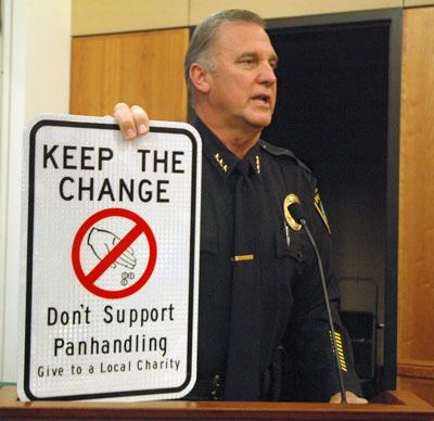 Arlington Police Chief Nelson Beazley holds up a street sign of the type that Marysville Police Chief Rick Smith reported has resulted in a drastic decrease in panhandling in Marysville.