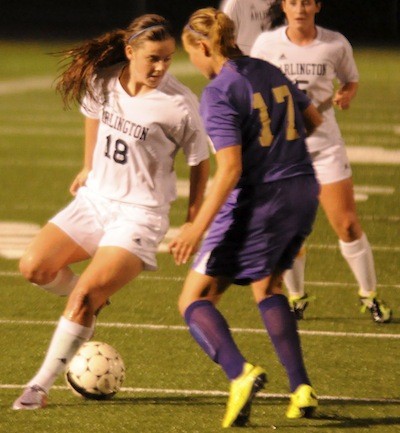 Arlington's Olivia Larson displays fancy footwork to dribble past an Oak Harbor defender.