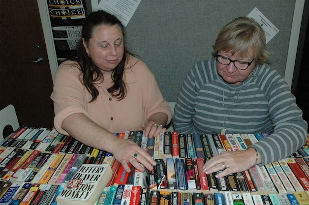 Friends of the Arlington Library members Char O'Neal and Nancy Yonker thumb through the selection at their monthly book sale on Nov. 13.