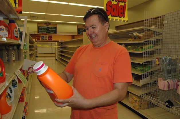 Marysville's Wenceslao Soto snags one of the few remaining items on the shelves of the Arlington Haggen Food & Pharmacy.