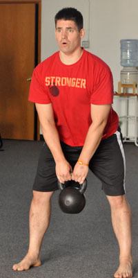 Trainer Aaron Ransford demonstrates how to use a kettlebell at the gym he opened with fellow trainer Lucy Hansen
