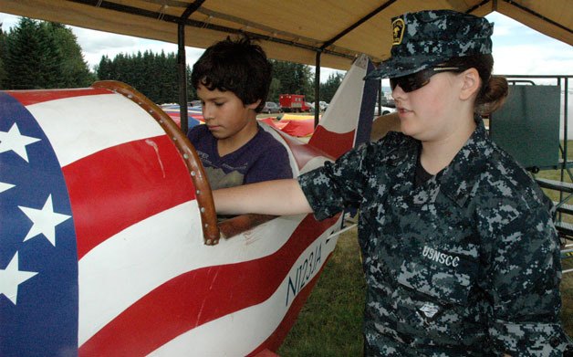 Nicholas McKune is guided on the Arlington Fly-In’s flight simulators by Seaman Recruit Nicolle Valenzuela of the U.S. Naval Sea Cadet Corps on July 12.