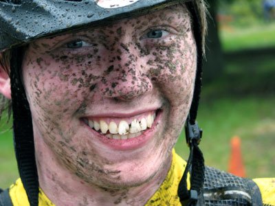 Lakewoodâ€™s Tyler Mueller grins after competing in a mountain bike race involving a large amount of mud.