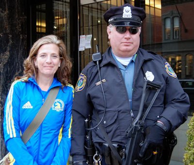 Patti Crookshank poses with a Boston police officer after finishing her second Boston Marathon on April 15.