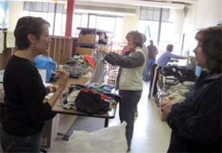 Arlington Kiwanis Club member Kris Carter helps Linda Dussault and Sukey Miller help sort clothes for kids at Kids Kloset in a work party of the Arlington Kiwanis Club April 4.