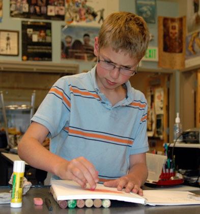 Twelve-year-old Jacob Rengen colors in his â€śAll About Meâ€ť art book on Wednesday