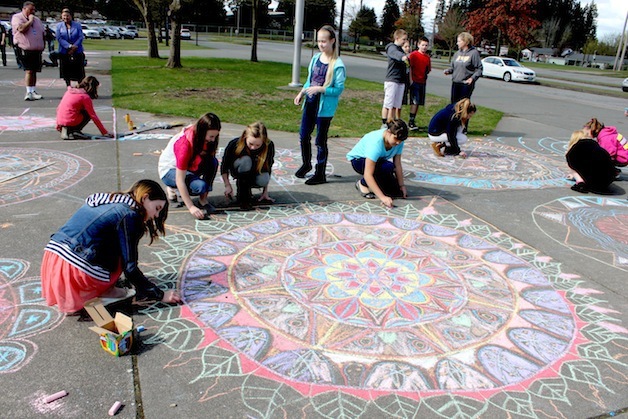 Post Middle School students create mandalas on the sidewalk in front of their school on April 9. In the front from left