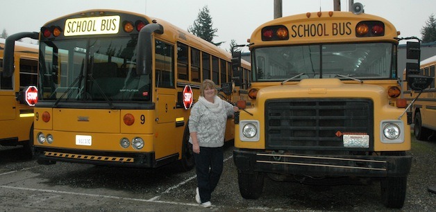 Arlington school bus driver Dana McCollum stands by one of the district's newest buses