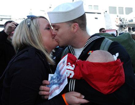 Arlington's Katie and Jody Davis share one of the first kisses coming off the brow of the USS Abraham Lincoln on March 24