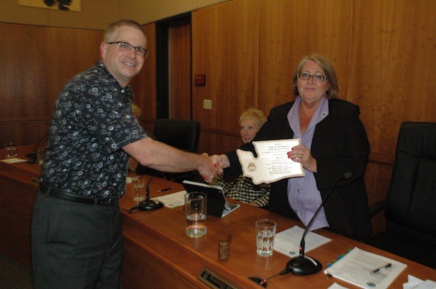 Arlington Public Works Director Jim Kelly presents a plaque from the state Transportation Improvement Board to Mayor Barbara Tolbert July 21.