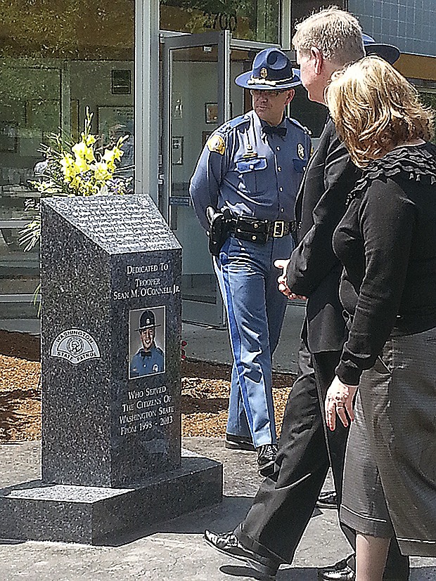 People walk by the monument to Trooper Sean M. O'Connell Jr. Friday
