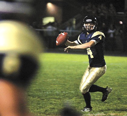 Arlington junior quarterback Blake McPherson looks downfield to throw to a receiver against Marysville-Pilchuck.