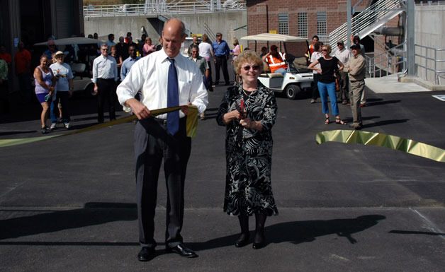 U.S. Rep. Rick Larsen holds the ceremonial ribbon while Arlington Mayor Margaret Larson cuts it to dedicate the city’s wastewater treatment plant on Aug. 24.
