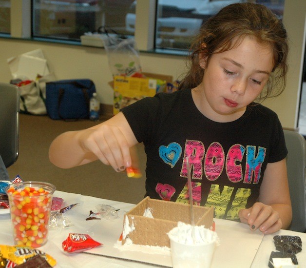 Ali Giles adopts ideas from her fellow builders in constructing her own 'edible haunted house' at the Arlington Boys & Girls Club Oct. 29.