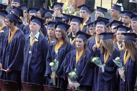 Arlington High Schoolâ€™s graduating seniors wait patiently while their fellow graduating students walk across the football field to be seated for the schoolâ€™s graduation ceremony Friday