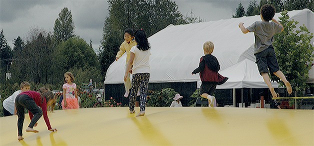 Children bounce around on the giant yellow pillow that was part of the activities at the Bryant Blueberry Festival.