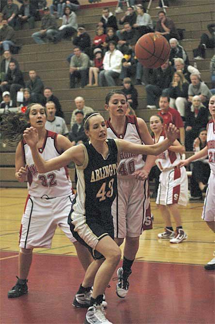 Senior Ginny Wilson fights back a pair of Snohomish would-be rebounders.