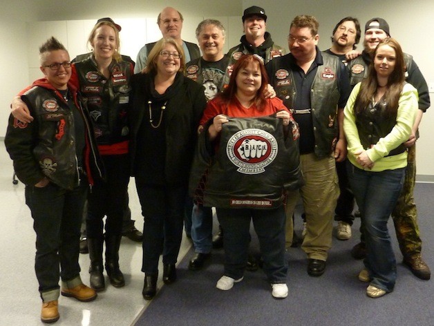 Members of the North Sound Chapter of the nonprofit Bikers Against Child Abuse organization are all smiles with Arlington Mayor Barbara Tolbert