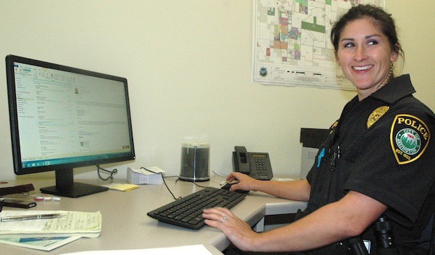 Stephanie Ambrose logs onto the computer at the Arlington Police Smokey Point substation.