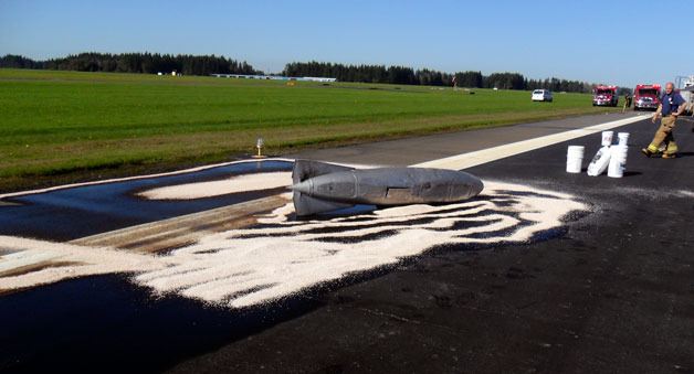 Crews from the Arlington Fire Department and Arlington Airport work to contain and clean up a fuel spill on the main runway of the Arlington Airport after the fuel cell fell of an Mig-15 as it was landing Oct. 13.