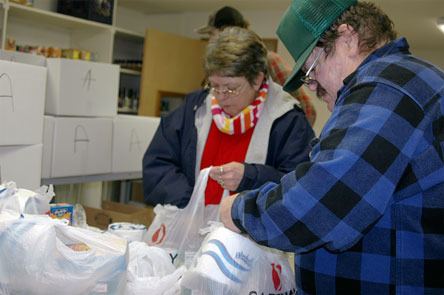 Volunteers Shirley McLane and Robert LaCourse pack up food items on Dec. 22 at the Arlington Community Food Bank.